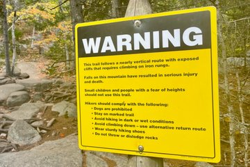 Ein Schild warnt vor den Gefahren des Trails